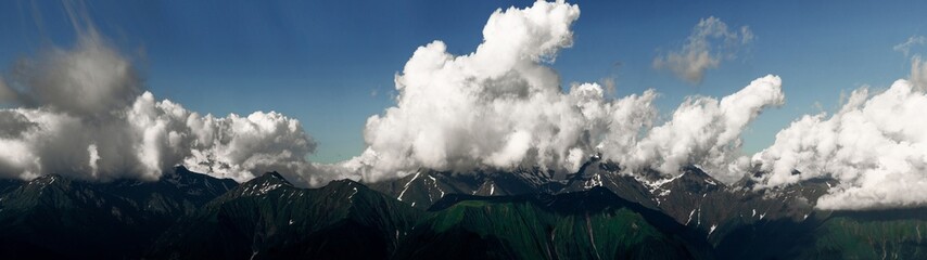 Beautiful mountain landscape, clouds over the peaks of the mountains, sunny day