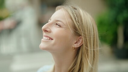 Young blonde woman breathing with closed eyes at street