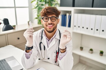 Arab doctor man with beard holding covid test winking looking at the camera with sexy expression,...