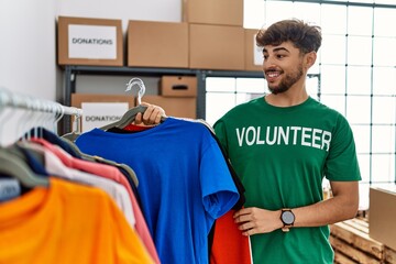 Young arab man wearing volunteer uniform working at charity center