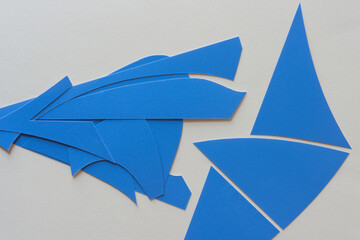 cut blue paper shapes arranged on blank paper