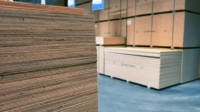 Stacks of sheet plywood lie in a warehouse of a woodworking factory