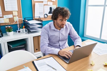 Fototapeta premium Young hispanic man business worker using laptop working at office
