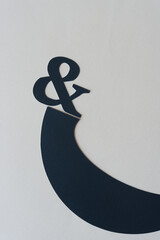 ampersand resting lightly on an elegant black paper shape