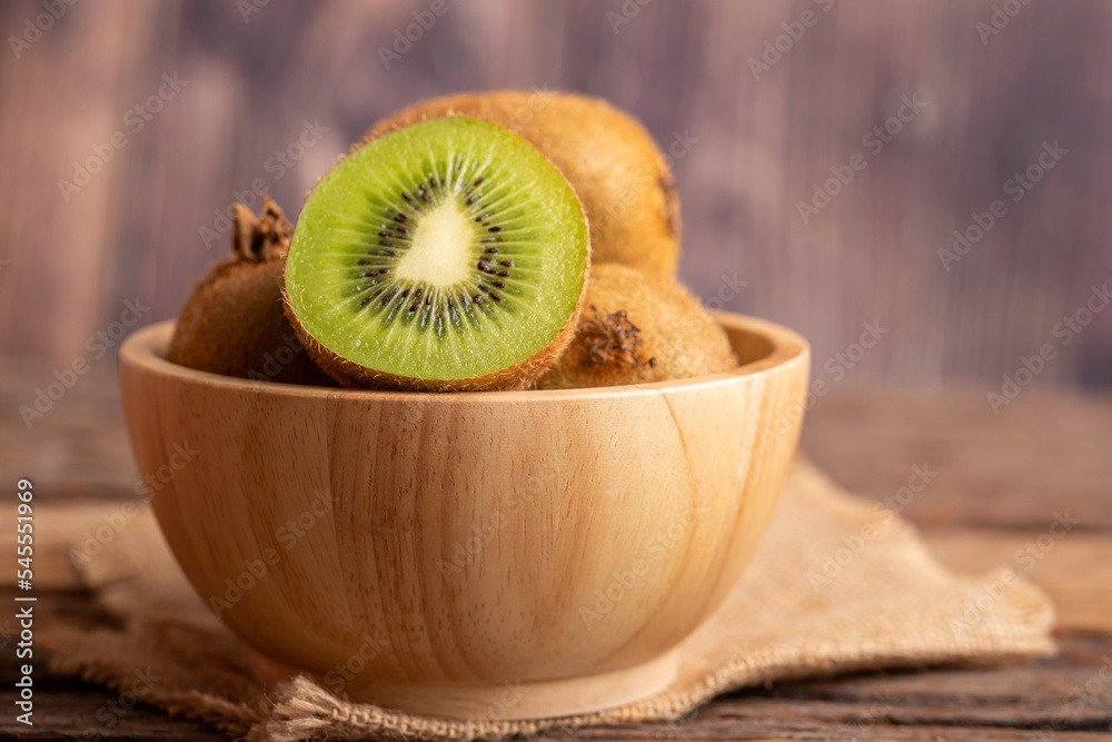 Wall mural close up a half of fresh green kiwi in a wood bowl