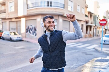 Fototapeta premium Young hispanic man smiling confident listening to music at street