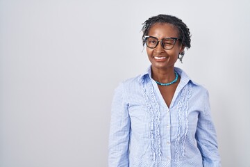 African woman with dreadlocks standing over white background wearing glasses winking looking at the camera with sexy expression, cheerful and happy face.