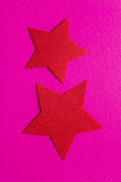 two red felt stars on pink card stock with embossed pattern (hearts)