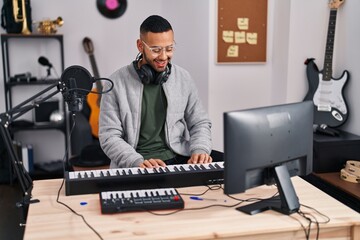 African american man musician playing piano keyboard at music studio