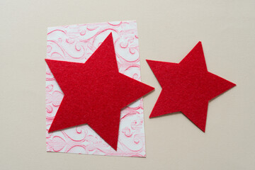 two red felt stars on paper (one with fancy pattern)