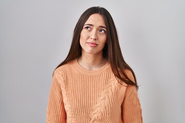 Obraz premium Young brunette woman standing over white background looking sleepy and tired, exhausted for fatigue and hangover, lazy eyes in the morning.