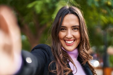 Young hispanic woman smiling confident make selfie by the camera at park