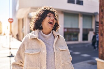 Young beautiful hispanic woman smiling confident looking to the side at street