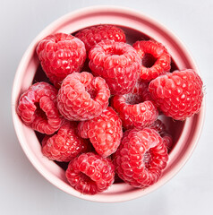  Delicious group of raspberries on ceramic bowl over isolated white background