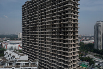 Aerial view of large abandoned concrete shell of residential high-rise real estate and construction development. Close  up of structure.