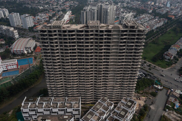 High angle aerial view of facade and rooftop of large abandoned concrete shell of residential...