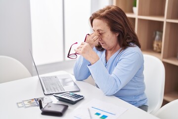 Senior woman stressed using laptop at home