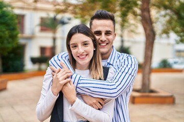 Man and woman couple smiling confident hugging each other at park