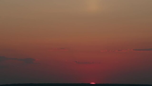 Beautiful dramatic fiery sunset over horizon in field in colorful sky. Sunset in yellow sky. Timelapse.
