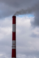 Fototapeta na wymiar Brick pipe of a heating plant against a cloudy sky.