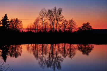 Fototapeta na wymiar Colourful tree reflections after sunset. Serpentine Fen, Surrey, BC