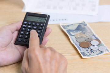 小銭と電卓　物価高　生活苦
