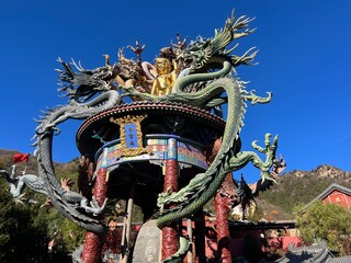 Baipu temple - detail from roof - small golden buddha with chinese dragon statue - dragon nestle