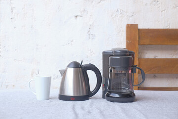 Coffee grinder, coffee machine and a cup on the table with white background. Copy space for design. Morning concept.