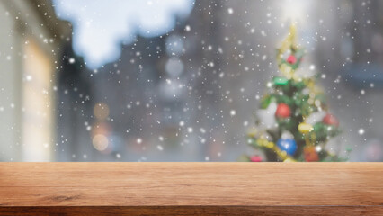 Naklejka na ściany i meble Empty wood table top on blur with bokeh Christmas tree and new's year decoration on window banner background with snowfall - can be used for display or montage your products.