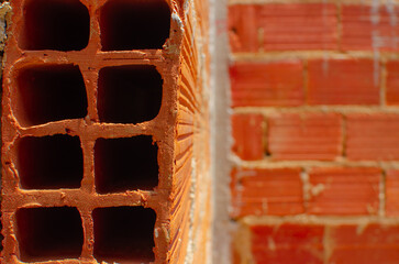 Brick wall under construction of brazilian house, brick under construction in brazil. blocks or bricks (masonry) of red clay on a wall, in the work of Brazilians.