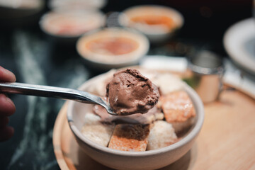 Chocolate ice cream on spoon, dessert in a metal spoon for eating ice cream.