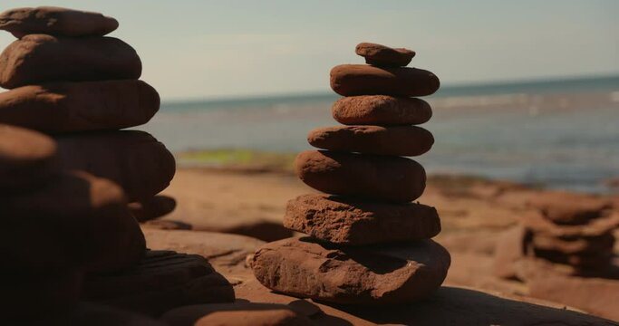 Inuksuk rock sculpture balancing in front of calm ocean water - zen