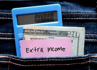 Calculator, cash dollars money and pink note with handwritten text EXTRA INCOME , concept of make...