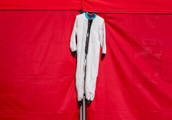 Hanging karting racer suit on tent on motorsport field, close up