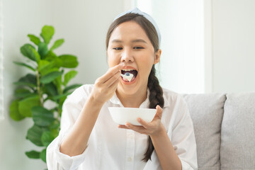 Healthy lifestyle, wellness food asian young woman hand use spoon eat tasty fresh organic yogurt,...