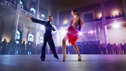 Couple dancers perform latin dance on large professional stage. Ballroom dancing. - obrazy, fototapety, plakaty