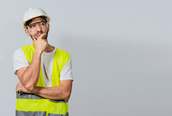Pensive builder man with hand on chin, Portrait of young builder thinking with hand on chin...