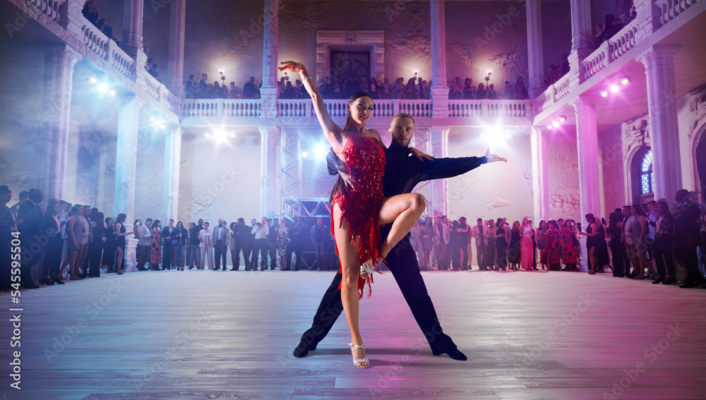 Wall mural couple dancers perform latin dance on large professional stage. ballroom dancing.