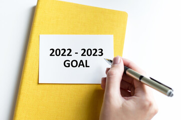 Businessman writes text on the card 2022-2023 goals