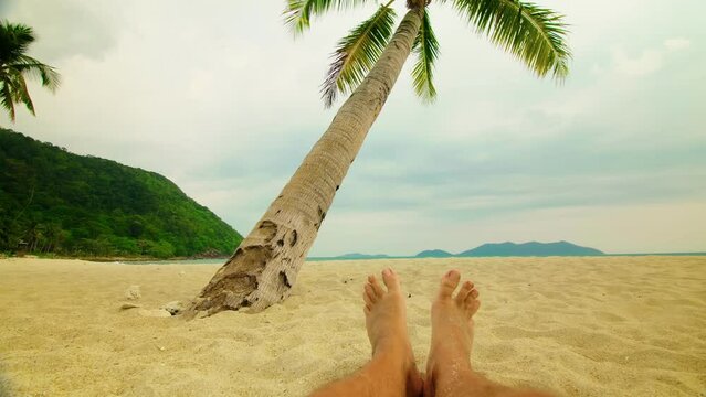 Beautiful Feet And Leg Man On Vacation.Tanned Man Relaxing Vacation Caribbean Tropical Beach.Summer Sunbathing On Resort Sea Or Ocean.Happy Guy Rest On Coast Hotel Luxury.Tropical Beach near Palm Tree