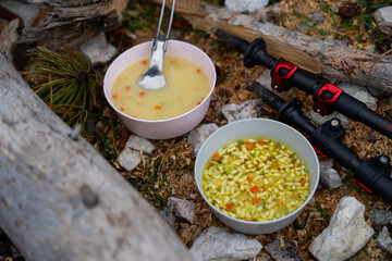 Two different soups in small bowls on a mountain