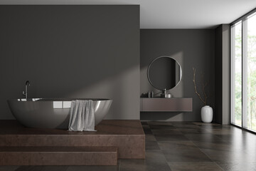 Front view on dark bathroom interior with bathtub, panoramic window
