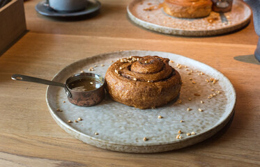 on the table in the cafe is a snail-shaped cake with melted butter in natural light.