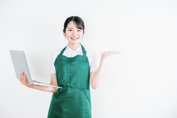 パソコンを持つエプロン姿の女性
