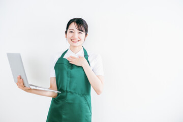 パソコンを持つエプロン姿の女性
