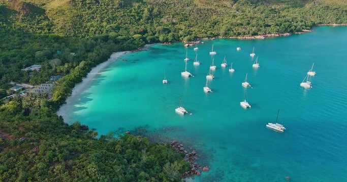 Aerial panning view Catamarans anchored at the magnificent Anse Lazio beach with it's azure coloured waters Praslin,Seychelles