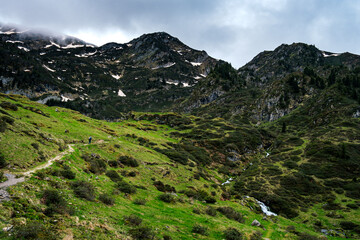 Hiking trail in the pastures nears Ayes Lake in the French Pyrenees mountains range on a cloudy day