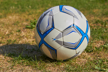 soccer ball on dry grass,a soccer ball lies on a soccer field with yellowed grass at sunset