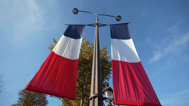 Wide angle view of national flag of France against blue sky during Armistice Day, 4k video.