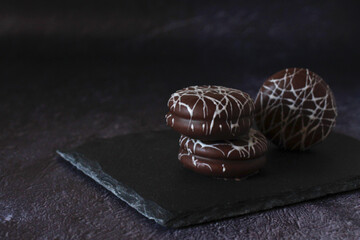 chocolate round cake in white glaze on a dark background